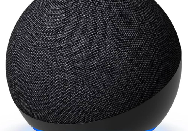 The Amazon Echo Dot smart speaker. A dark grey spherical speaker emitting a blue-turquoise light from its base.