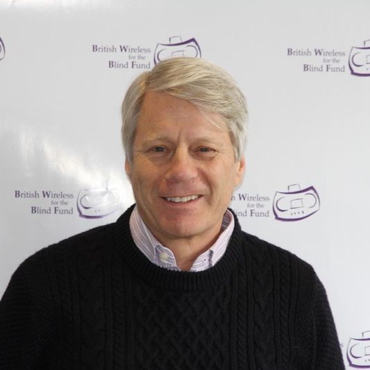 BWBF Patron Nick Ross smiles to camera. He is wearing a black jumper with a pale shirt underneath