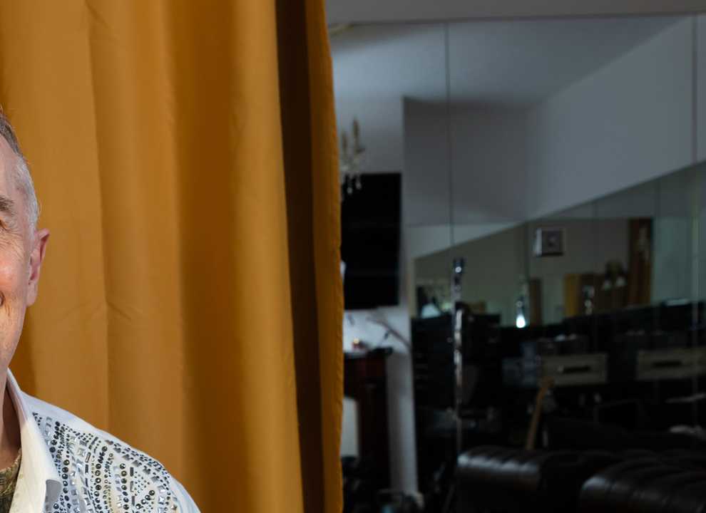 BWBF service user Paul smiles broadly as. He has grey hair and a patterned shirt.